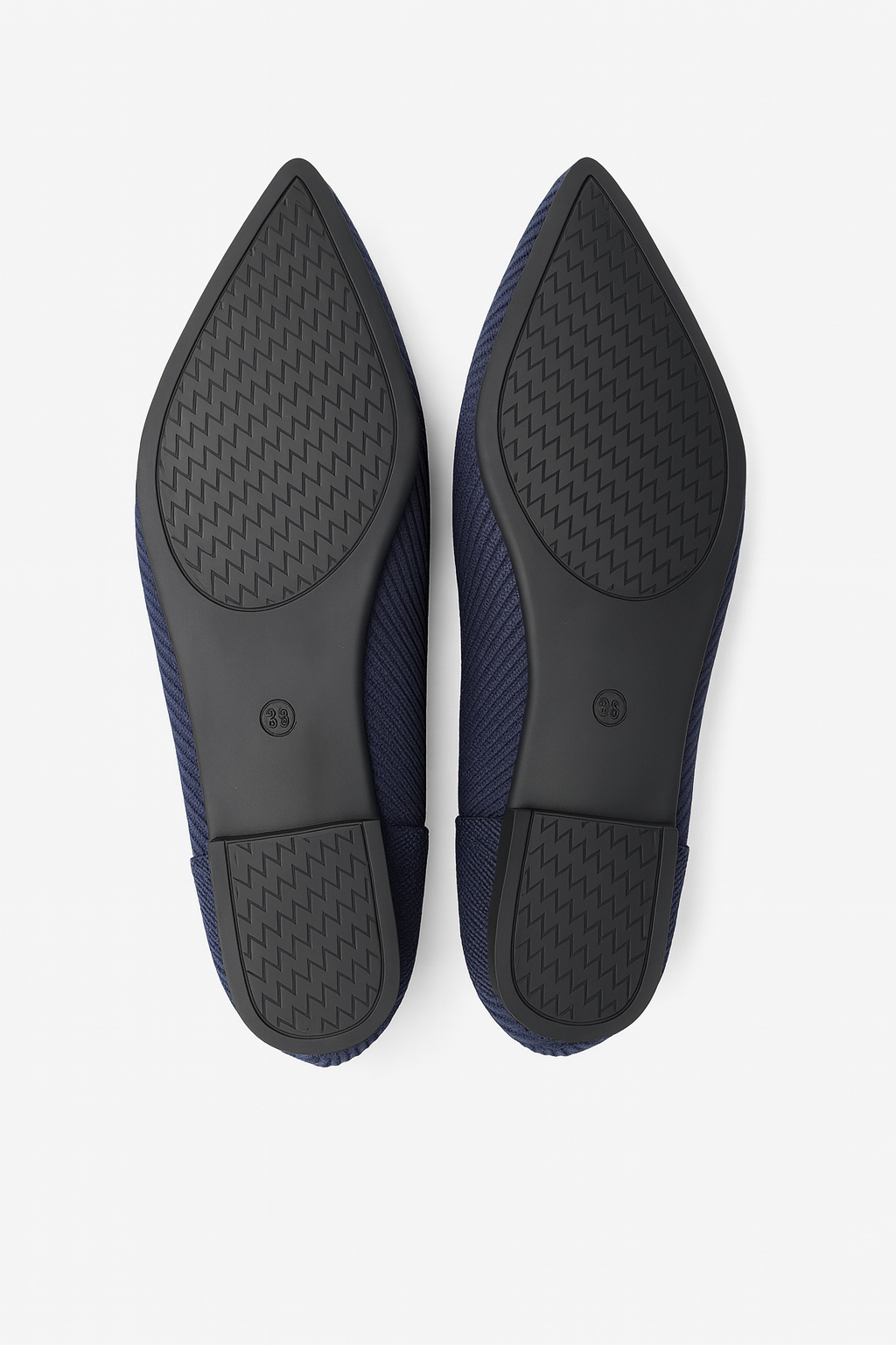 Pair of navy blue shoes with black soles on a white background