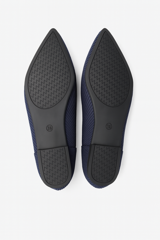 Pair of navy blue shoes with black soles on a white background
