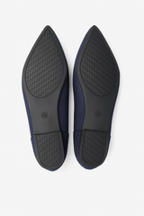 Pair of navy blue shoes with black soles on a white background